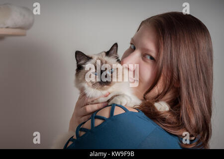 Junge Frau umarmte ihre Seal Point Birma Katze, 9 Monate alten Katze, Mann mit blauen Augen Stockfoto