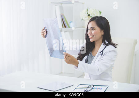 Ärztin, Blick auf eine Röntgenaufnahme in ihrem Büro Stockfoto