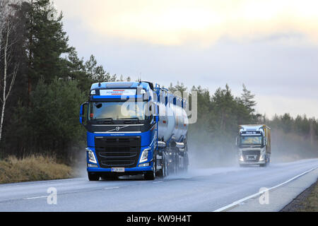 RAASEPORI, Finnland - 27 Dezember, 2017: Blaue Volvo FH Tankwagen mit Pulver Trans und anderen Volvo Truck Transport waren entlang nasse Autobahn an einem regnerischen da Stockfoto