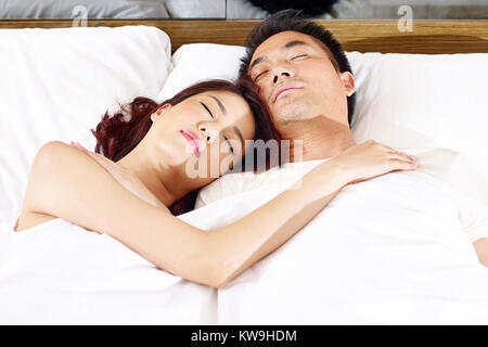 Asiatische Paar schlafen im Bett zu Hause oder im Hotel. Stockfoto