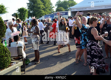 Frauen in schönen Kleidern trinken und tanzen in einer Bar im Royal Ascot. Stockfoto
