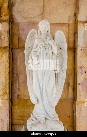 Alte weiße Engel Statue in der Kirche mit Steinmauer Hintergrund. Stockfoto