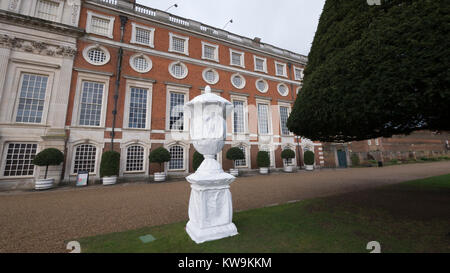 Steinerne Statue in Kunststoff winter Schutzhülle mit Baum Formgehölze in Hampton Court Palace abgedeckt Stockfoto