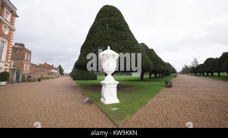 Steinerne Statue in Kunststoff winter Schutzhülle mit Baum Formgehölze in Hampton Court Palace abgedeckt Stockfoto