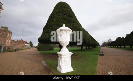 Steinerne Statue in Kunststoff winter Schutzhülle mit Baum Formgehölze in Hampton Court Palace abgedeckt Stockfoto