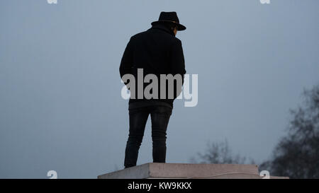 Mann in Trilby Hut gegen bewölkter Himmel Silhouette Stockfoto