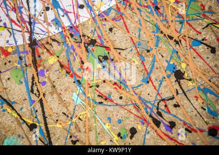 Alle Farben des Regenbogens auf weißem Tuch und Beton mit Paint gewirbelt. Stockfoto