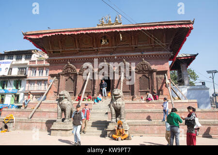 Unter der gutartigen Blicke von Shiva und Parvati, Besucher erforschen die die Shiva-Parvati Tempel in Durbar Square, Kathmandu, Nepal. Stockfoto