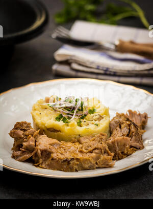 Confit Schweinekamm mit Kartoffelpüree auf steinernen Tisch Stockfoto