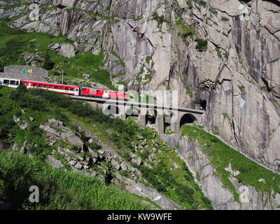 ANDERMATT, Schweiz Europa auf Juli 2017: Express St. Gotthard Bahn auf Teufelsbruecke, eisenbahnbrücke Devil's und Tunnel, der Schweizer Alpen. Stockfoto