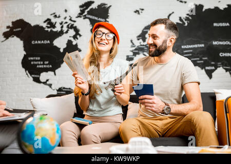 Junges Paar sitzen mit Eiffelturm im Reisebüro Büro auf der Weltkarte Hintergrund prepairing für eine Reise nach Paris. Stockfoto