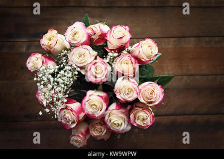 Blick von oben auf einen schönen Blumenstrauß ein Dutzend rote und weiße Rosen mit Baby's Atem Schuß von oben. Selektiver Fokus auf Rosen mit extremen shallo Stockfoto