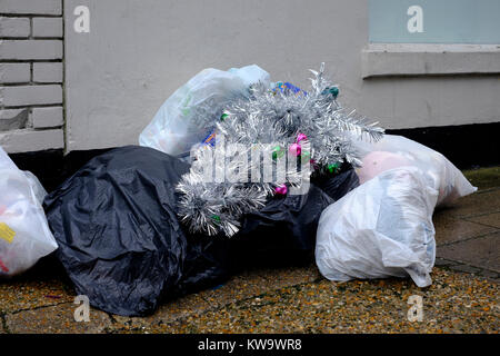 Einen künstlichen Weihnachtsbaum wird zusammen mit Säcke Müll zu Beginn des neuen Jahres England uk gedumpten Stockfoto