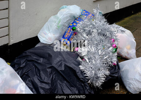 Einen künstlichen Weihnachtsbaum wird zusammen mit Säcke Müll zu Beginn des neuen Jahres England uk gedumpten Stockfoto