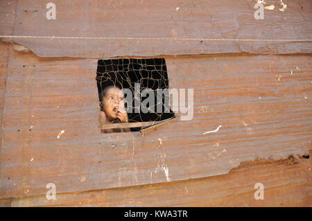 Ein Kind schaut in den Himmel durch einen schmalen Fenster in einem shanty Hause Korail Slum in Dhaka, der Hauptstadt von Bangladesch am 20. Juli 2009. Der Slum ist die Heimat Stockfoto