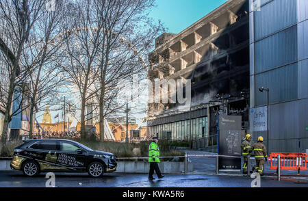 Feuerwehr am Parkhaus Park in der Nähe der Echo Arena in Liverpool, nach der letzten Nacht Brand, Hunderte von Autos zerstört. Stockfoto