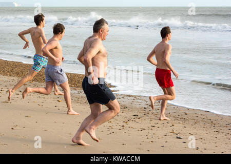 Boscombe, Bournemouth, Dorset, Großbritannien. 1.. Januar 2018. Badende, die nur Badehosen tragen, trotzen dem kalten Wasser des Ärmelkanals mitten im Winter, um den Neujahrstag zu feiern. Schwimmen im Meer im Winter. Stockfoto