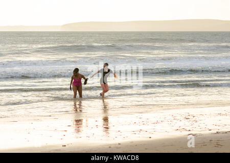 Paar, das am Neujahrstag aus dem Meer läuft, Boscombe, Bournemouth, Dorset, Großbritannien. 1.. Januar 2018. Stockfoto