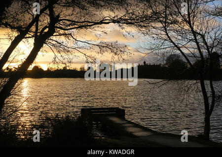 Lurgan, Nordirland. 01. Januar, 2018. UK Wetter - ein gemischter Tag mit Sonnenschein und Duschen mit kaltem Wind. Sonnenuntergang über Lurgan Park See. Quelle: David Hunter/Alamy leben Nachrichten Stockfoto