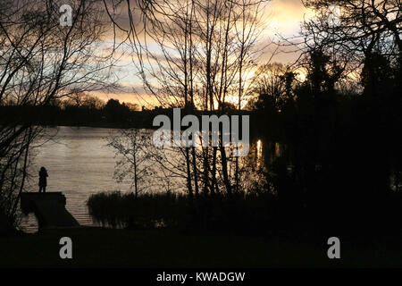 Lurgan, Nordirland. 01. Januar 2018. UK Wetter - ein gemischter Tag mit Sonnenschein und Duschen mit kaltem Wind. Person takiing Foto von winter Sonnenuntergang am Telefon. Quelle: David Hunter/Alamy leben Nachrichten Stockfoto