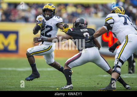 Tampa, Florida, USA. 1 Jan, 2018. Michigan Wolverines zurück läuft, Chris Evans (12) Erhält ein Pitch und ist in Südcarolina Kampfhähne Defensive zurück KEISEAN NIXON (9) Während der Outback Bowl bei Raymond James Stadium gebracht. Credit: Travis Pendergrass/ZUMA Draht/Alamy leben Nachrichten Stockfoto