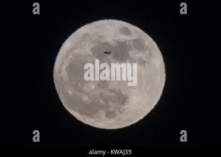 Chicago, USA. 1 Jan, 2018. Ein Flugzeug über die supermoon steigen über Lake Michigan von North Avenue Beach am Neujahrstag gesehen. Der Mond ist an seinem nächsten Punkt, dem Perigäum, auf der Erde während seiner monatlichen Orbit und erscheint 30 % mehr Helligkeit und 14 % größer. Januar 2018 sieht eine supermoon als "Wolf Moon' am 1. Januar und ein "Blue Moon" am 31. Januar bekannt. Credit: Stephen Chung/Alamy leben Nachrichten Stockfoto