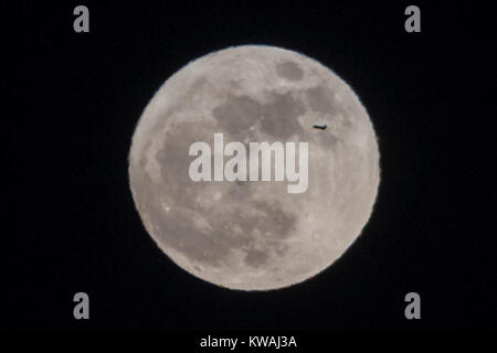 Chicago, USA. 1 Jan, 2018. Ein Flugzeug über die supermoon steigen über Lake Michigan von North Avenue Beach am Neujahrstag gesehen. Der Mond ist an seinem nächsten Punkt, dem Perigäum, auf der Erde während seiner monatlichen Orbit und erscheint 30 % mehr Helligkeit und 14 % größer. Januar 2018 sieht eine supermoon als "Wolf Moon' am 1. Januar und ein "Blue Moon" am 31. Januar bekannt. Credit: Stephen Chung/Alamy leben Nachrichten Stockfoto