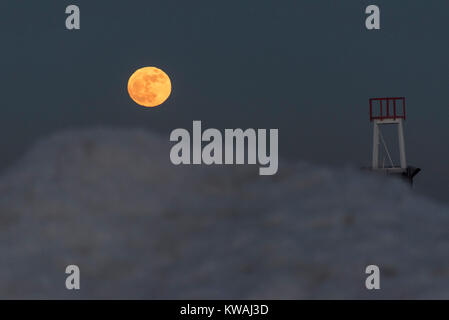 Chicago, USA. 1 Jan, 2018. Die supermoon steigt hinter dem Steg am Eis bedeckt North Avenue Beach an einem der kältesten Tage des neuen Jahres seit Jahrzehnten. Der Mond ist an seinem nächsten Punkt, dem Perigäum, auf der Erde während seiner monatlichen Orbit und erscheint 30 % mehr Helligkeit und 14 % größer. Januar 2018 sieht eine supermoon als "Wolf Moon' am 1. Januar und ein "Blue Moon" am 31. Januar bekannt. Credit: Stephen Chung/Alamy leben Nachrichten Stockfoto