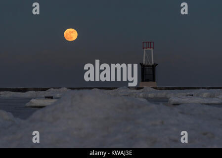 Chicago, USA. 1 Jan, 2018. Die supermoon steigt hinter dem Steg am Eis bedeckt North Avenue Beach an einem der kältesten Tage des neuen Jahres seit Jahrzehnten. Der Mond ist an seinem nächsten Punkt, dem Perigäum, auf der Erde während seiner monatlichen Orbit und erscheint 30 % mehr Helligkeit und 14 % größer. Januar 2018 sieht eine supermoon als "Wolf Moon' am 1. Januar und ein "Blue Moon" am 31. Januar bekannt. Credit: Stephen Chung/Alamy leben Nachrichten Stockfoto