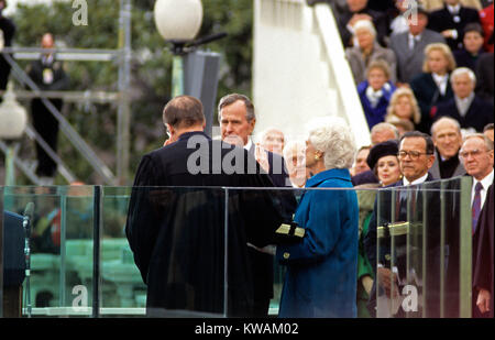 Präsidenten der Vereinigten Staaten George H.W. Bush ist vereidigte als 41. Präsident der Vereinigten Staaten, die von Chief Justice William Rehnquist an den US Capitol am 20. Januar 1989. First Lady Barbara Bush (trägt einen blauen Mantel) schaut auf, während die Familie Bibel halten. Erkennbar sind die Mitglieder des Kongresses auf der rechten Seite gehören US-Senator Ted Stevens (Republikaner von Alaska), US-Senator (Republikaner Alan Simpson von Wyoming) und Sprecher des US-Repräsentantenhaus Jim Wright (Demokrat von Texas). Credit: Ron Sachs/CNP - KEINE LEITUNG SERVICE - Foto: Ron Sachs/Konsolidierte/dpa Stockfoto