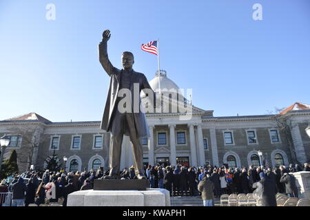 Mineola, United States. 01 Jan, 2018. Mineola, New York, USA. Januar 1, 2018. Historische Vereidigung von Laura Curran als Nassau County Executive, der erste weibliche County Executive, statt draußen. Die Temperatur war ein Einfrieren 14 ℉ Fahrenheit/-10 °C Celsius für den Outdoor Zeremonie vor der Theodore Roosevelt Executive and Legislative Building, und die Menschen im Publikum hielt stand zusammen schließen und sich in der Nähe der großen eingangstreppe Schritte. Metall Statue von Präsident Theodore Roosevelt ist im Vordergrund. Quelle: Ann E Parry/Alamy leben Nachrichten Stockfoto