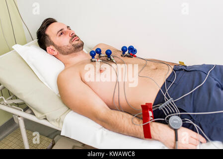 Junger Mann tun präventiven EKG im Krankenhaus Stockfoto