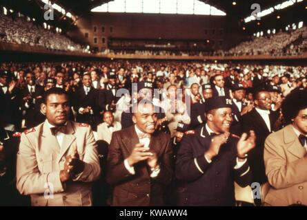 Männer in einer Menge von über 10 000 Muslime Elijah Muhammad während der Lieferung von Tag die Botschaft seines jährlichen Retter in Chicago, Illinois, März, 1974 begrüßen. Mit freundlicher Genehmigung der nationalen Archive. Stockfoto