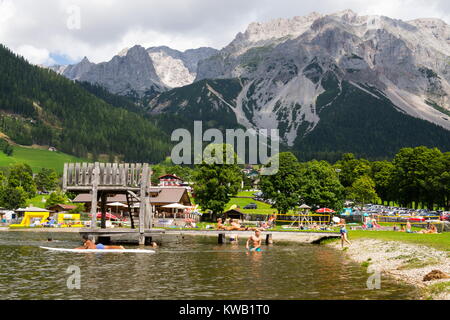 RAMSAU AM DACHSTEIN, Österreich - 17. August: Menschen entspannen in Rittisberg Vergnügungspark mit Dachstein im Hintergrund. Stockfoto