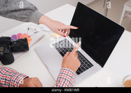 Zwei Fotografen mit Kamera und Laptop arbeiten im Büro Stockfoto