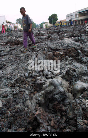 Wenn der Nyriragongo Vulkan auf 18/01/2002 ausbrach, Lava floss in Goma in der Demokratischen Republik Kongo, zerstören ein Drittel der Stadt. Menschen, die über die Kühlung lava entlang Was war eines der Hauptziele von Goma Straßen. Stockfoto