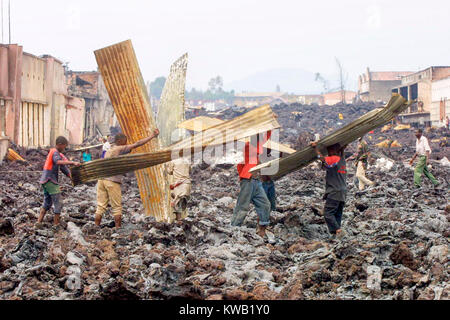 Wenn der Nyriragongo Vulkan auf 18/01/2002 ausbrach, Lava floss in Goma in der Demokratischen Republik Kongo, zerstören ein Drittel der Stadt. Menschen, die über die Kühlung lava Spülpumpe was können sie von den zerstörten Gebäuden. Stockfoto