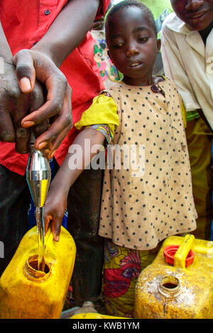 Cyuve Camp, Ruanda, für die Flüchtlinge aus dem Nyriragongo Vulkanausbruch am 18 Jan 2002 in der Nähe von Goma in der Demokratischen Republik Kongo. Ein junges Mädchen füllt Ihren Container an einem Wasser. Stockfoto