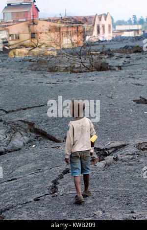 Wenn der Nyriragongo Vulkan auf 18/01/2002 ausbrach, Lava floss in Goma in der Demokratischen Republik Kongo, zerstören ein Drittel der Stadt. Da die Lava gekühlt Die meisten Menschen zurück. Hier ein Junge wandert der Lava-gefüllte Straßen. Stockfoto