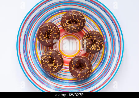 5 Tesco festliche Mini Donuts in einem Ring auf bunte Platte mit Ringen auf Weiß gesetzt Stockfoto