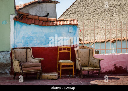 Alte abgenutzte Möbel vor einem alten Haus Wand links Stockfoto