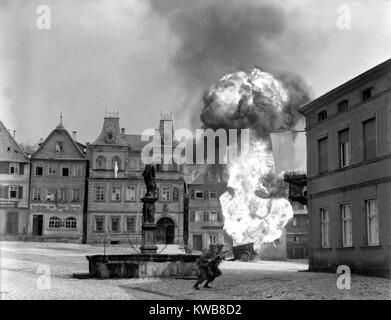 Zwei Soldaten dash Vergangenheit einen flammenden Deutsche benzin Trailer im Marktplatz von Kronach, Deutschland. U.S. 101st Infantry, 14. April 1945. Weltkrieg 2. (BSLOC 2014 8 75) Stockfoto