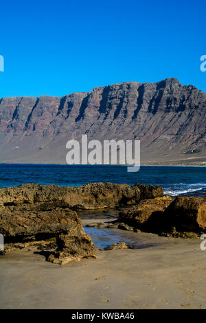 Der Strand und Klippen, Caleta de Famara, Lanzarote, Kanarische Inseln, Spanien. Stockfoto