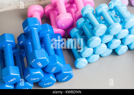 Farben Blau und Rosa Hanteln liegen auf dem grauen Fußboden. Studio shot Stockfoto
