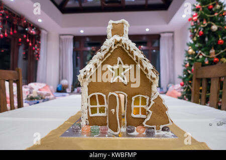 Ein lebkuchenhaus an erster Stelle steht in der Mitte der einen Esstisch. Stockfoto