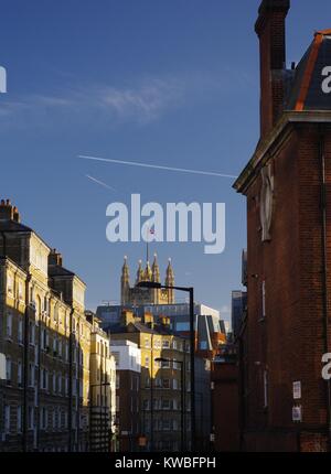 Stadtbild entlang einer Londoner Straße in Richtung Victoria Tower, Palast von Westminster, Großbritannien, unter einem blauen Himmel. Stockfoto