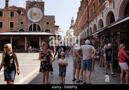 Viele Touristen und gif Geschäfte durch San Giacomo di Rialto Kirche in Venedig/Italien. Katholische gotischen Gebäude aus 1071 CE circa, mit einem großen, legendären Stockfoto