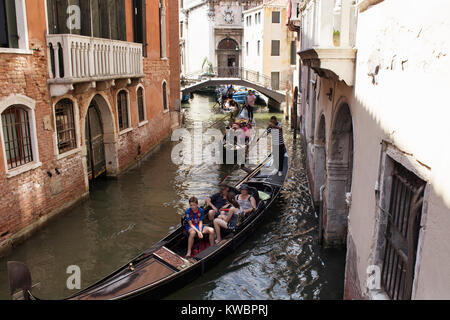 Touristen fahren Gondeln Tour auf Kanälen zwischen alten, historischen Gebäuden in Venedig/Italien. Stockfoto