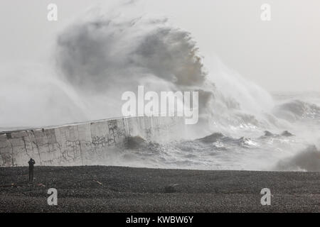 Newhaven, Sussex, UK; man am Strand machen Fotos der hoch aufragenden Wave markante Ufermauer im Sturm Stockfoto