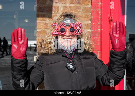 Ein Zuschauer am Tag die 114 Polar Bear Club Das neue Jahr Schwimmen das Tragen der roten Handschuhe und 2018 Sonnenbrille. Stockfoto